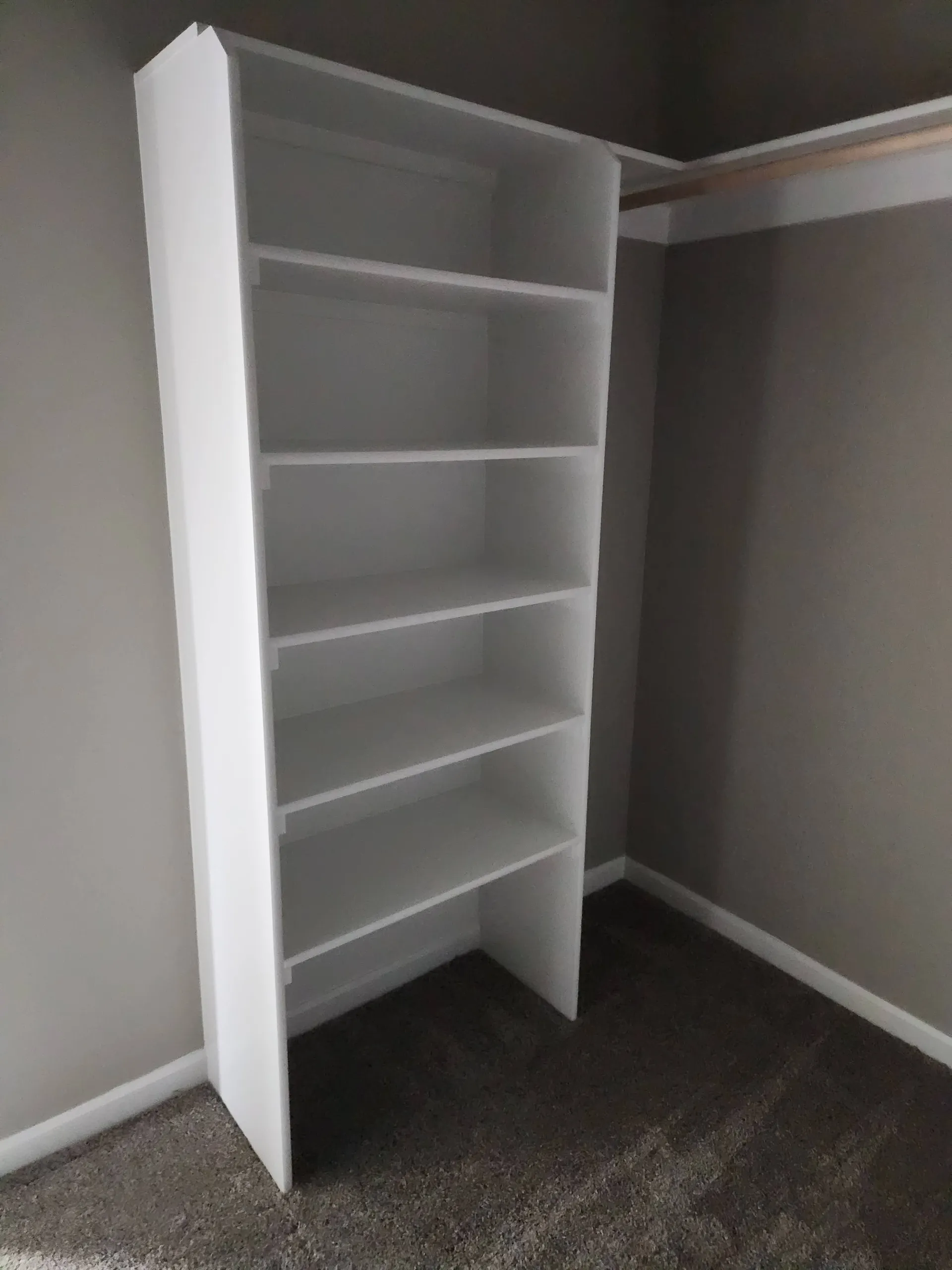 Closet with a built-in shelving tower and hanging rod