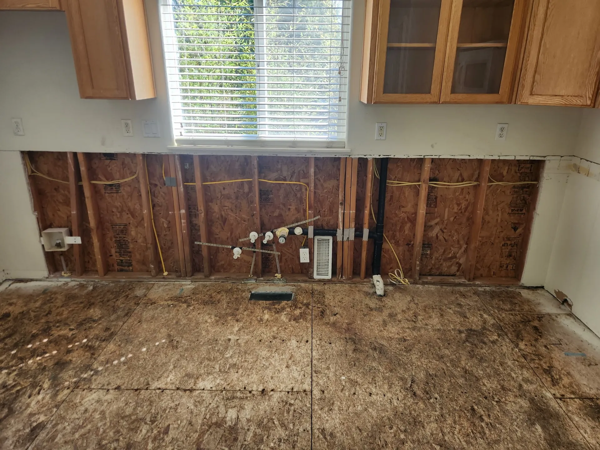 Kitchen wall with the lower drywall cut out to the studs
