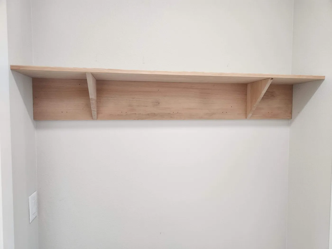 Wood shelf hung on a white wall