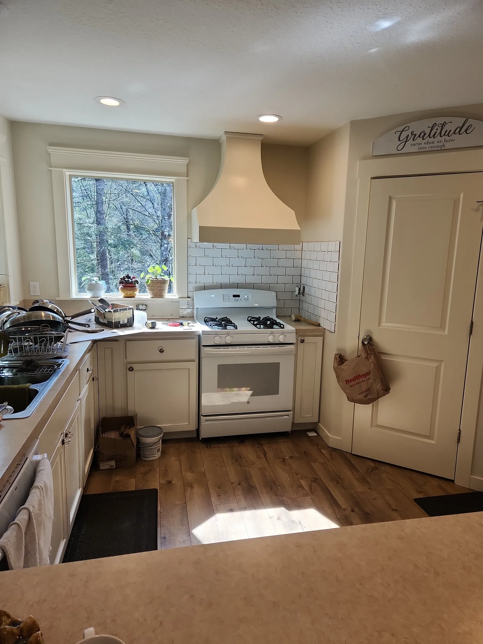 Kitchen with a subway tile backsplash under a range hood