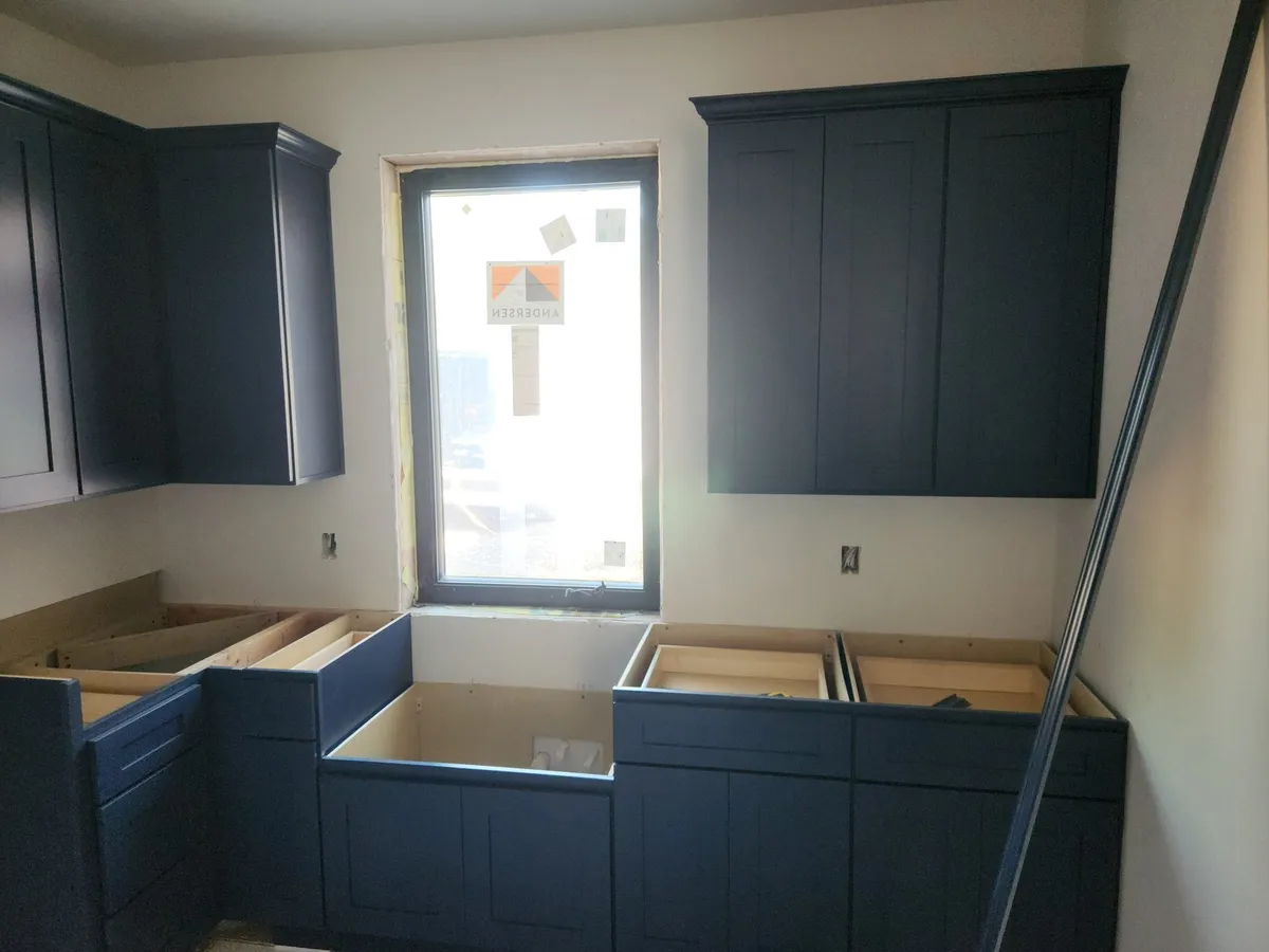 Navy kitchen cabinets being installed