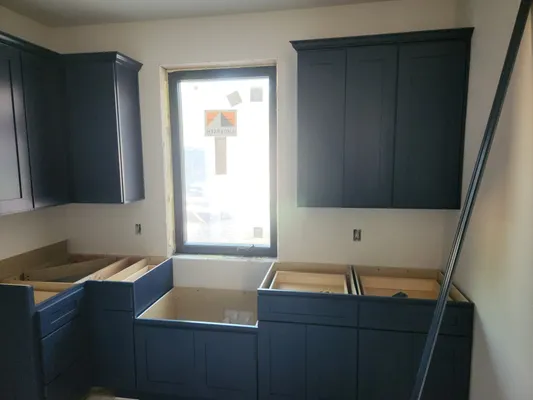 Navy kitchen cabinets being installed