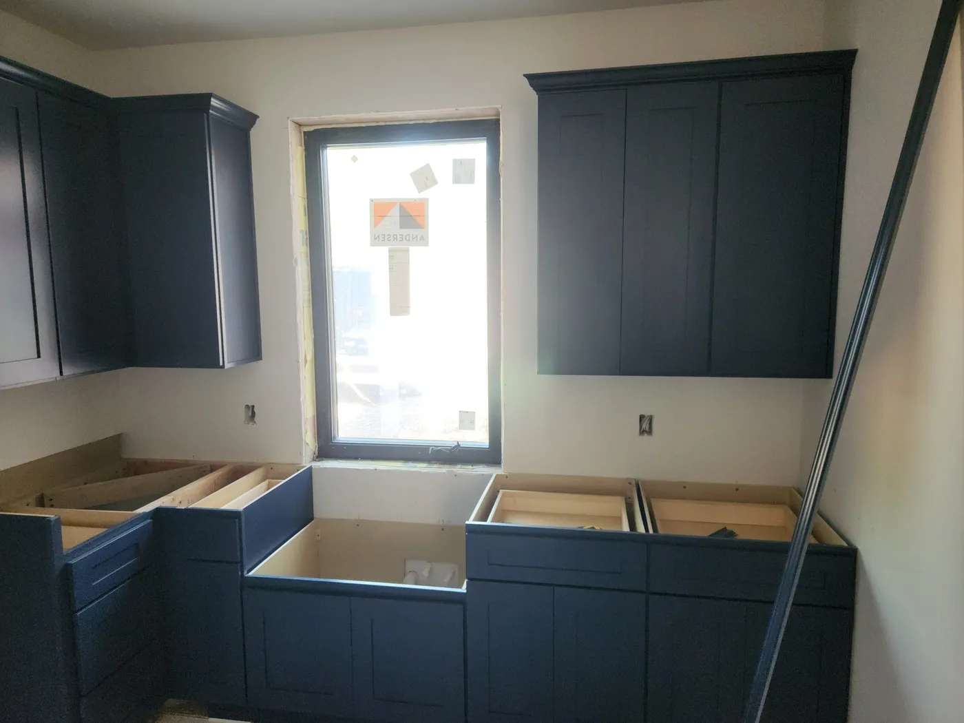 Navy kitchen cabinets being installed